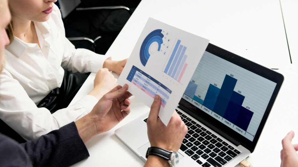 Team reviewing charts and reports on a laptop during a planning session