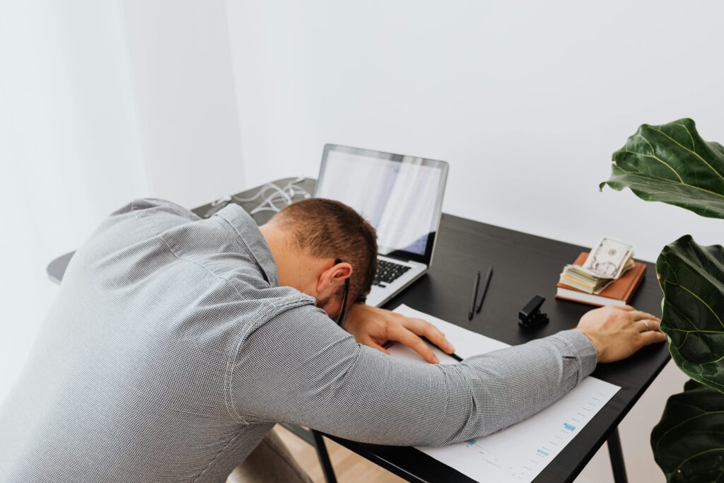 Overwhelmed business professional struggling with IT governance and technology decision-making at a desk
