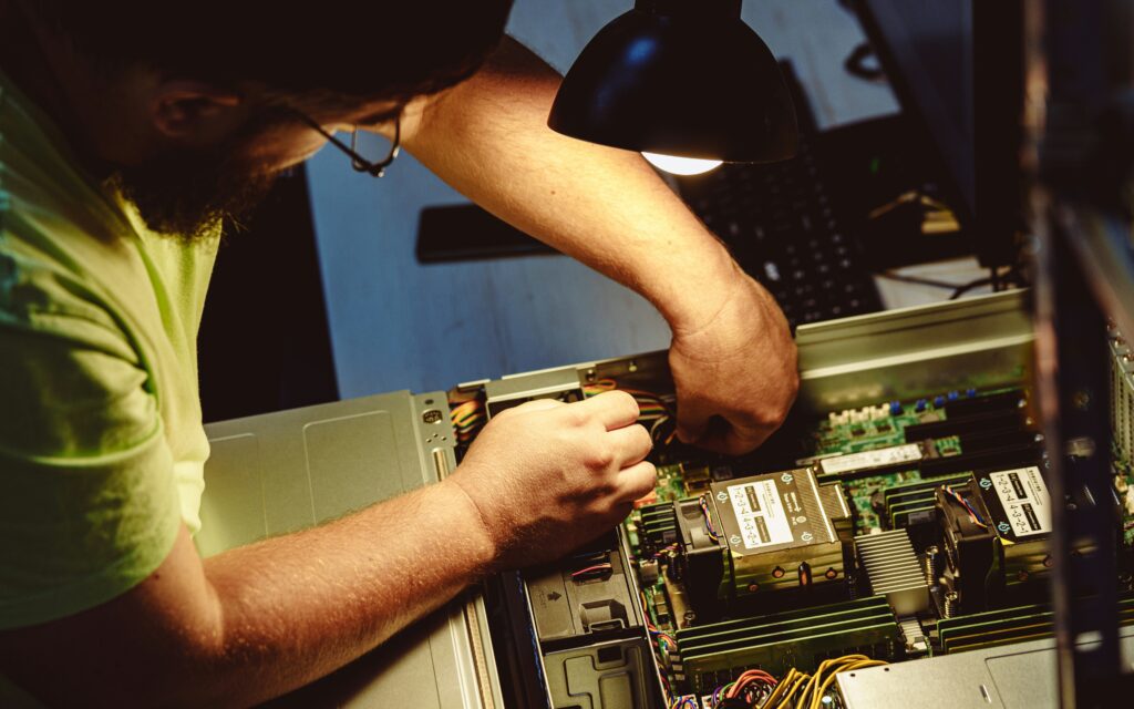 IT technician servicing server hardware to reduce downtime during an outage IT technician servicing server hardware to reduce downtime during an outage IT technician displaying a business continuity plan by servicing server hardware to reduce downtime during an outage
