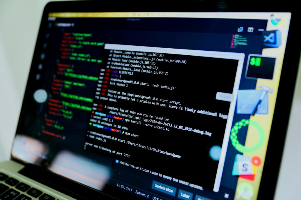 Close-up of a laptop screen showing code and a terminal window, representing complex system access and troubleshooting