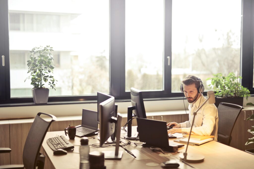 Managed help desk services technician providing remote support from a multi-monitor workstation