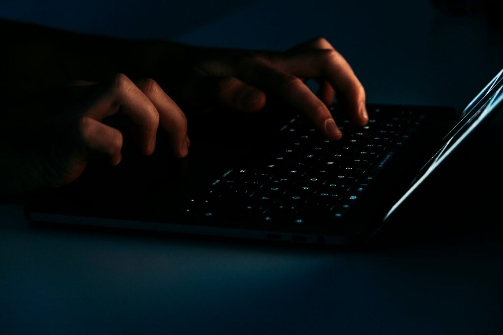 Hands typing on a keyboard in low light, representing unauthorized access risk when perimeter trust fails.
