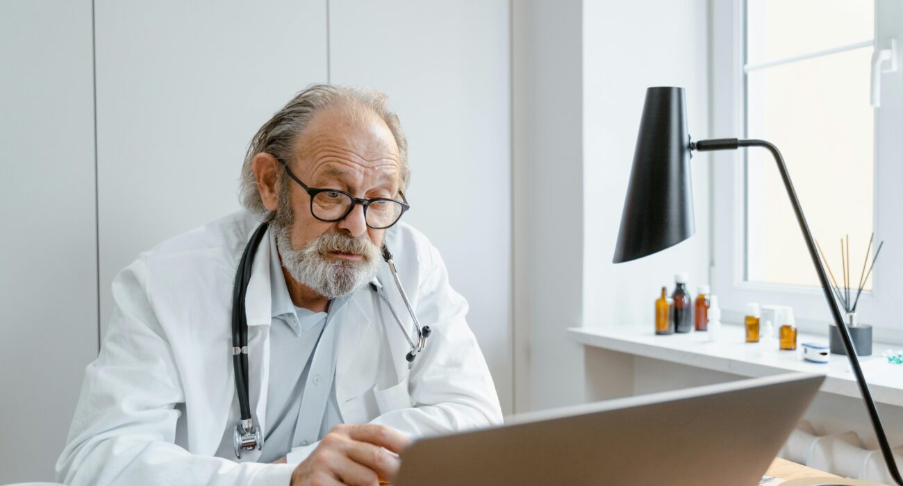 Doctor using a laptop during a telehealth session, representing managed IT services for healthcare