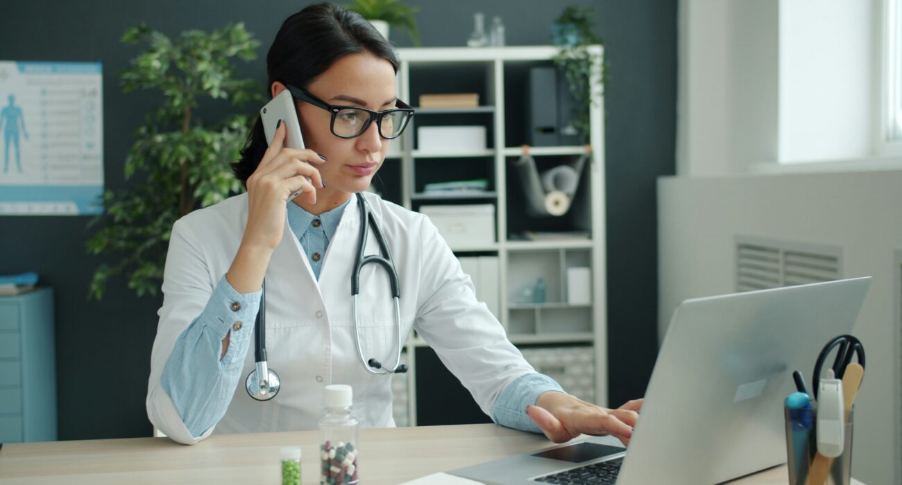 Doctor working on a laptop in a medical office, representing medical practice cybersecurity risks in Los Angeles