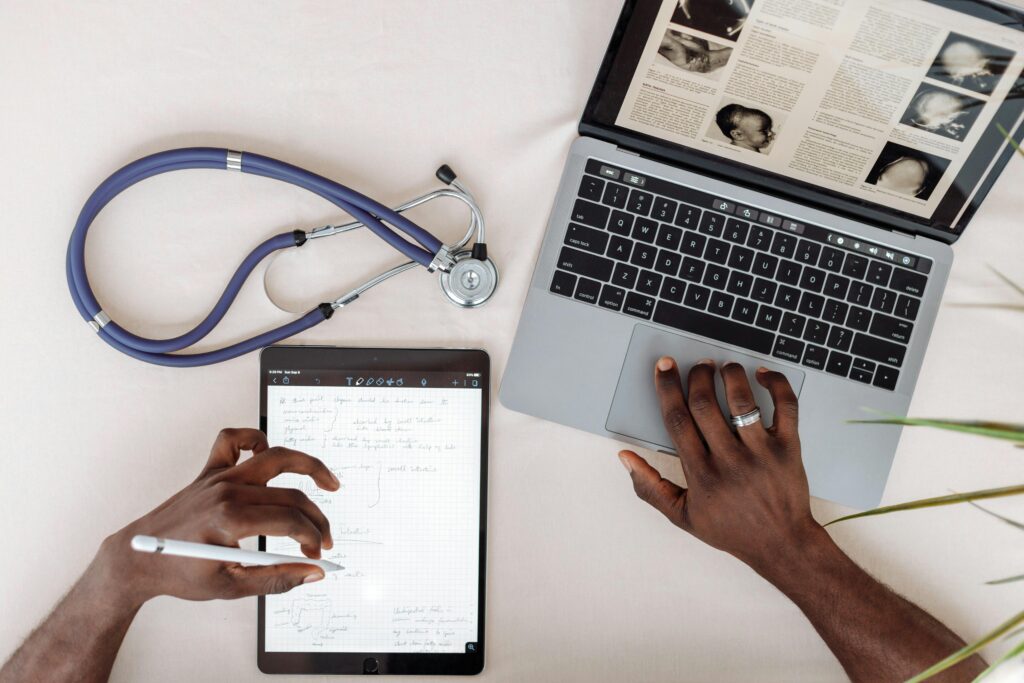 Healthcare worker using a laptop and tablet while completing a HIPAA compliance checklist review