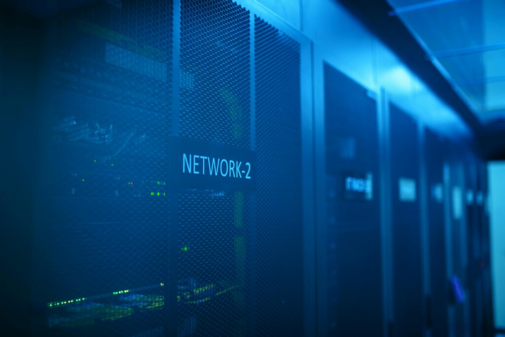 Blue-lit network server racks in a data center supporting business cybersecurity, backups, and risk management