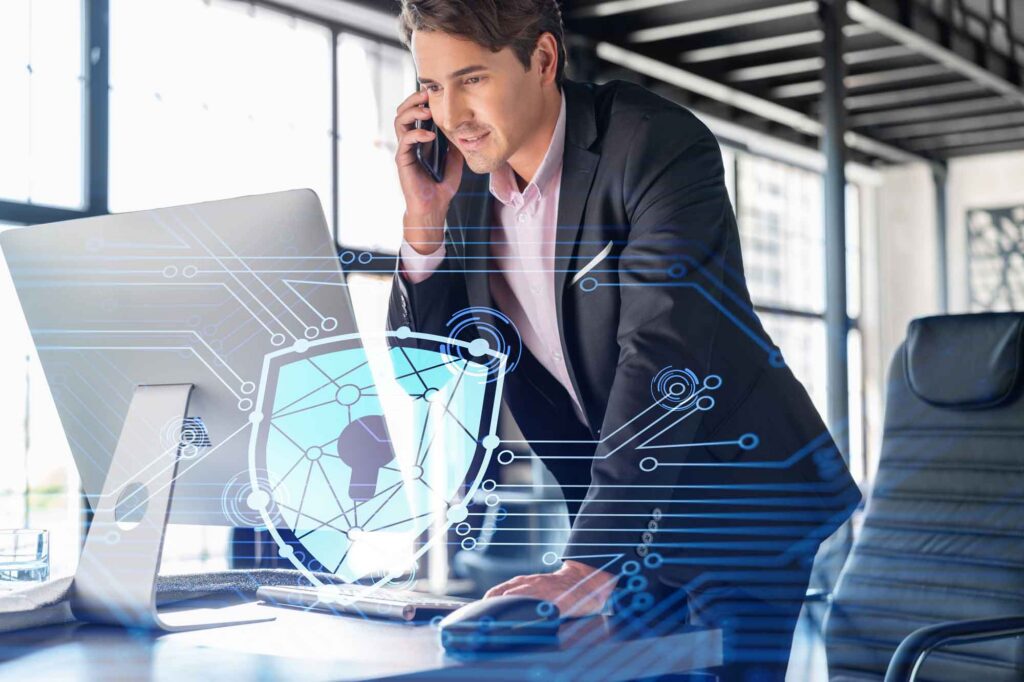 Business professional using a laptop with cybersecurity shield overlay for IT support in El Segundo
