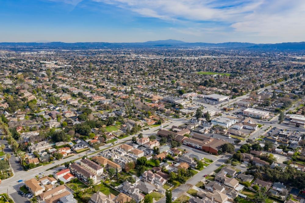 Aerial view of Arcadia, California, showing residential neighborhoods and local business districts under a blue sky.