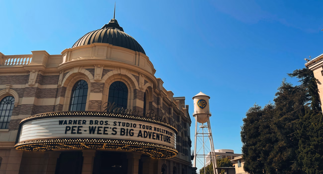Warner Bros. Studio Tour entrance and water tower beneath a blue sky in Burbank, California.